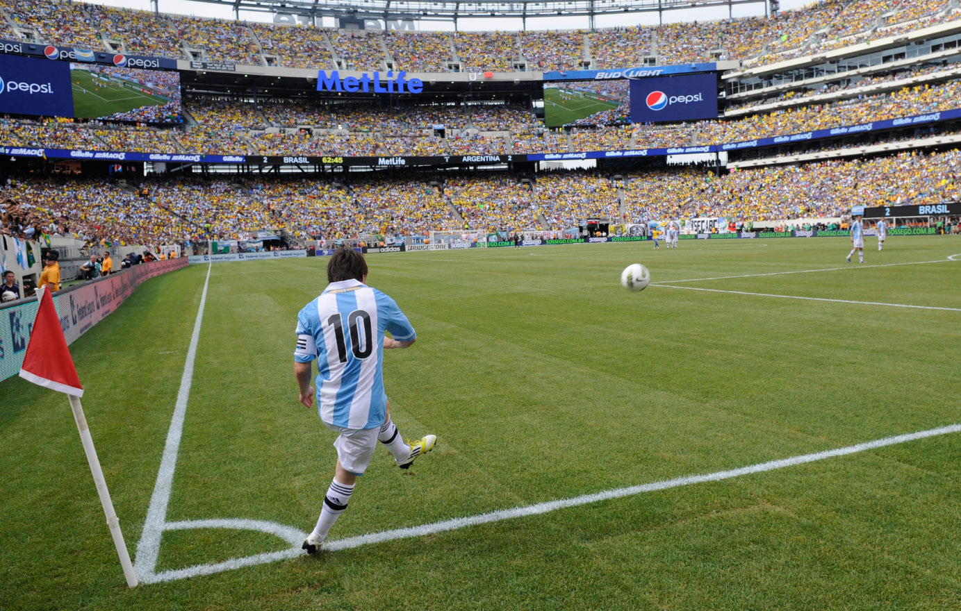 Lionel Messi taking a corner kick for Argentina in a packed MetLife Stadium.